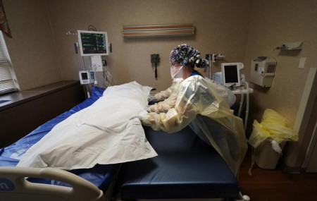 Medical staff move a COVID-19 patient who died onto a gurney to hand off to a funeral home van, at the Willis-Knighton Medical Center in Shreveport, La., Aug. 18, 2021.