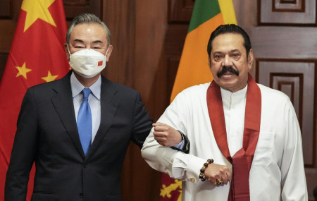 Chinese Foreign Minister Wang Yi, left, poses for media before his meeting with Sri Lankan Prime Minister Mahinda Rajapaksa in Colombo, Sri Lanka, Sunday, Jan. 9, 2022.