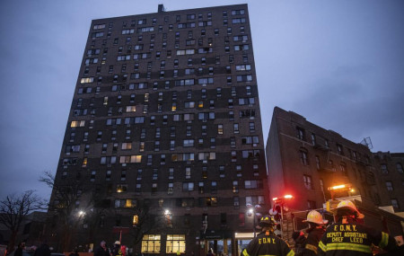 Emergency personnel work at the scene of a fatal fire at an apartment building in the Bronx on Sunday, Jan. 9, 2022, in New York.