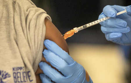 Medical personnel vaccinate a student at a school in New Orleans on Tuesday, Jan. 25, 2022.