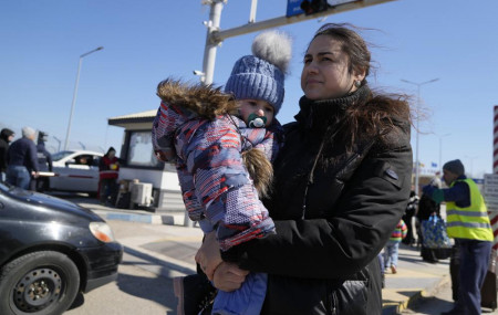 A woman carries her baby after fleeing the war from neighbouring Ukraine at the border crossing in Palanca, Moldova, Saturday, March 19, 2022.