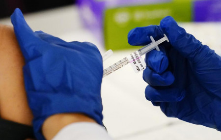 A health worker administers a dose of a Moderna COVID-19 vaccine during a vaccination clinic at the Norristown Public Health Center in Norristown, Pa., Tuesday, Dec. 7, 2021.