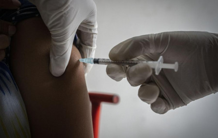 A woman receives her third dose of vaccine for COVID-19 at a private vaccination center in Gauhati, India, Sunday, April 10, 2022.
