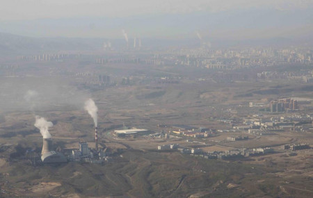 FILE - Smoke and steam rise from towers at the coal-fired Urumqi Thermal Power Plant as seen from a plane in Urumqi in western China's Xinjiang Uyghur Autonomous Region on April 21, 2021.