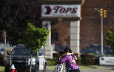 People hug outside the scene after a shooting at a supermarket on Saturday, May 14, 2022, in Buffalo, New York.