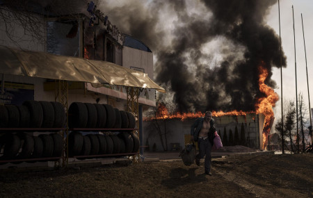 A man recovers items from a shop that caught fire from a Russian attack in Kharkiv, Ukraine, Friday, March 25, 2022. (AP Photo/Felipe Dana)