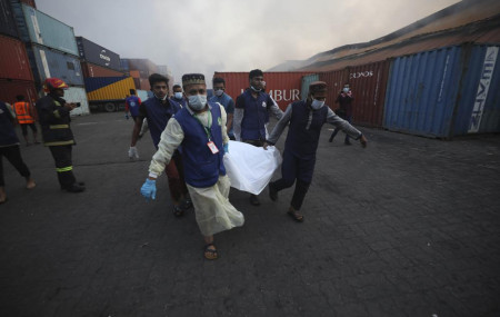 People carry the body of a victim after a fire broke out at the BM Inland Container Depot, a Dutch-Bangladesh joint venture, in Chittagong, 216 kilometers (134 miles) southeast of capital, Dhaka, Bangladesh, early Sunday, June 5, 2022.