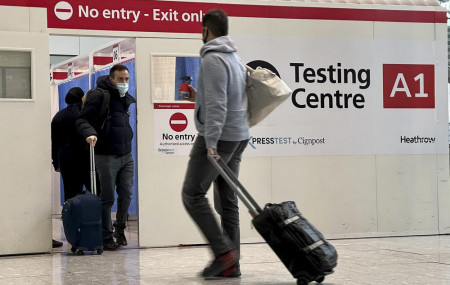 FILE - Passengers get a COVID-19 test at Heathrow Airport in London, Nov. 29, 2021.