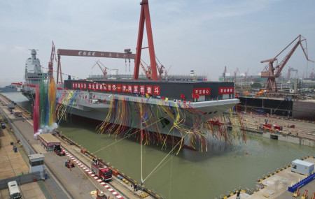 In this photo released by Xinhua News Agency, coloured smoke mark the launch ceremony for China's third aircraft carrier christened Fujian at a dry dock in Shanghai on Friday, June 17, 2022.
