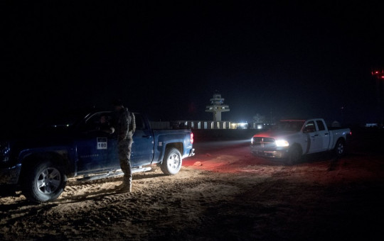 In this Dec. 26, 2018, file photo, members of the military wait outside facilities where President Donald Trump and first lady Melania Trump are visiting at Ain al-Asad air base, Iraq.