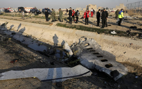 In this Jan. 8, 2020, photo, debris is seen from an Ukrainian plane which crashed as authorities work at the scene in Shahedshahr, southwest of the capital Tehran, Iran.