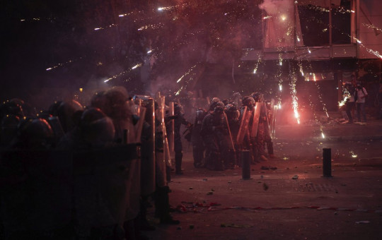 Fireworks thrown by anti-government protesters explode over Riot Police during clashes near the parliament building following last Tuesday's massive explosion in the seaport which devastated Beirut, Lebanon, Monday, Aug. 10, 2020.