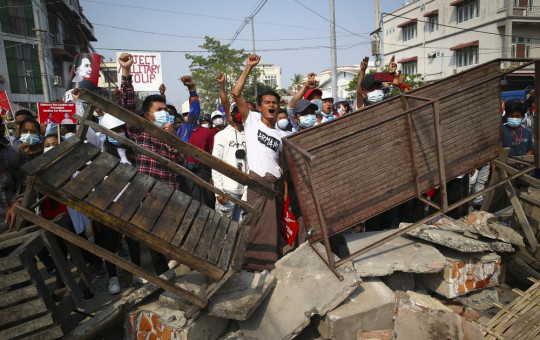 Protesters shout slogans as police arrive during a protest against the military coup in Mandalay, Myanmar, Sunday, Feb. 28, 2021.
