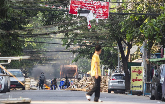 Police and military forces occupy a road block barricade in Yangon, Myanmar, Friday, March 19, 2021.
