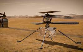 In this illustration, NASA's Ingenuity Mars Helicopter stands on the Red Planet's surface as NASA's Perseverance rover (partially visible on the left) rolls away. Photo Courtesy: NASA