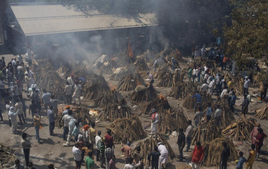 In this April 24, 2021, file photo, multiple funeral pyres of those who died of COVID-19 burn at a ground that has been converted into a crematorium for the mass cremation of coronavirus victims, in New Delhi, India.
