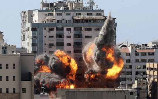 A ball of fire erupts from a building housing various international media, including The Associated Press, after an Israeli airstrike on Saturday, May 15, 2021 in Gaza City.