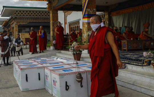 This photograph provided by UNICEF shows monks from Paro's monastic body perform a ritual as 500,000 doses of Moderna COVID-19 vaccine gifted from the United States arrived at Paro International Airport in Bhutan, July 12, 2021.