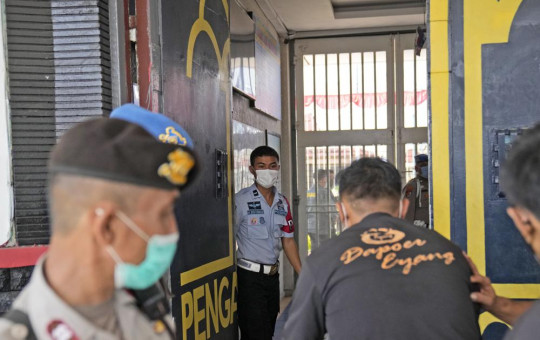 Staff and police officers guard the main entrance gate of Tangerang prison in Tangerang on the outskirts of Jakarta, Indonesia, Wednesday, Sept. 8, 2021.