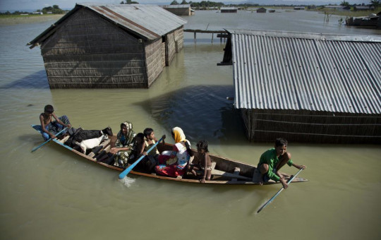In this July 31, 2016, file photo, a flood-affected family with their goats travel on a boat in the Morigaon district, east of Gauhati, northeastern Assam state, India.