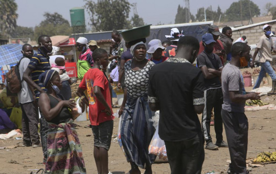People are seen at a busy market in a poor township on the outskirts of the capital Harare, Monday, Nov, 15, 2021.