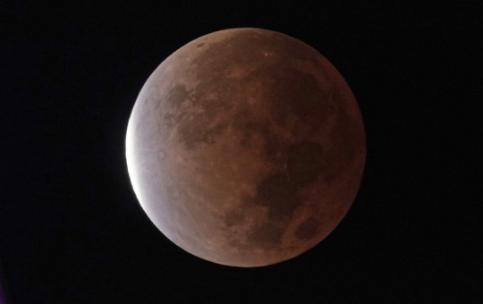 The earth's shadow covers the full moon during a partial lunar eclipse, early Friday, Nov. 19, 2021, in Kansas City, Missouri.