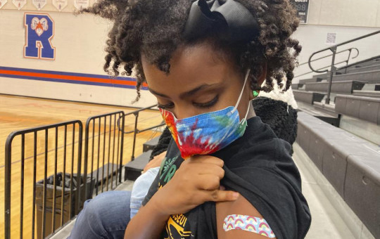 Solome Walker, 9, looks down at her bandage after getting her first Pfizer COVID-19 shot at a vaccination clinic for young students at Ramsey Middle School on Saturday, Nov. 13, 2021 in Louisville, Kentucky.