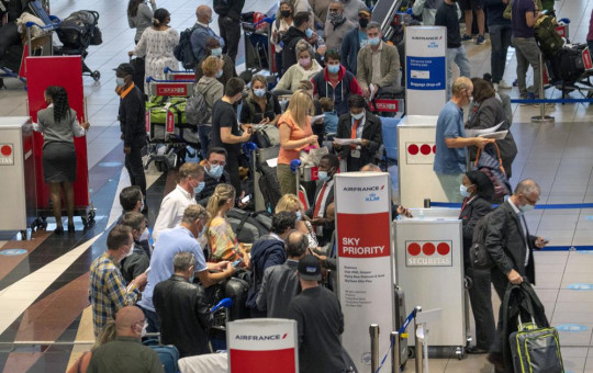 People line up to get on the Air France flight to Paris at OR Tambo International Airport in Johannesburg, South Africa, Friday Nov. 26, 2021.