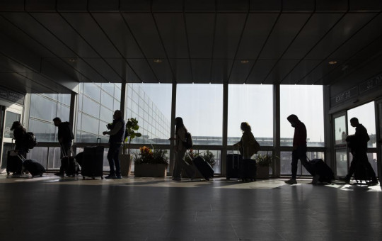 Travelers walk with their luggage in the Ben Gurion Airport near Tel Aviv, Israel, Sunday, Nov. 28, 2021.