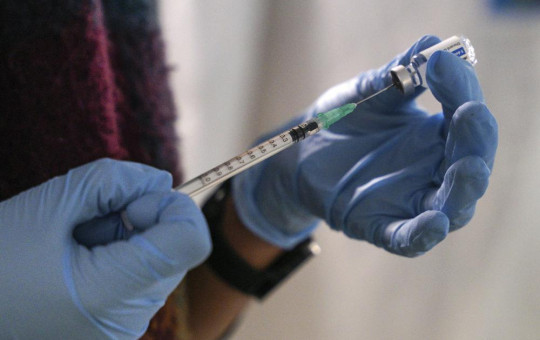 A staff member from the National Health Organisation (EODY) prepares a booster Johnson and Johnson vaccine against COVID-19 at Karatepe refugee camp, on the northeastern Aegean island of Lesbos, Greece, Wednesday, Dec. 15, 2021.