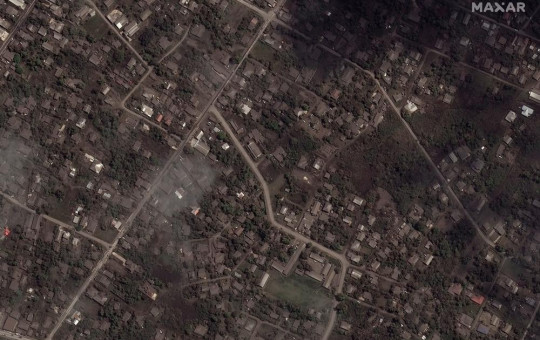 This satellite image provided by Maxar Technologies shows ash covered homes and buildings in Tonga Tuesday, Jan. 18, 2022 after a huge undersea volcanic eruption.