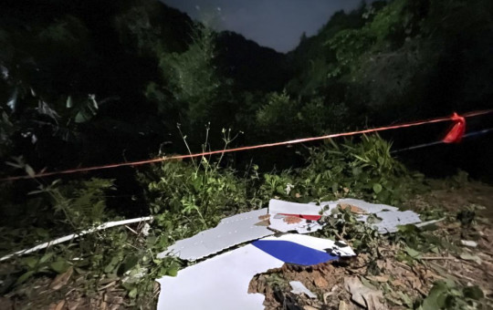 In this photo released by China's Xinhua News Agency, debris is seen at the site of a plane crash in Tengxian County in southern China's Guangxi Zhuang Autonomous Region, Tuesday, March 22, 2022.