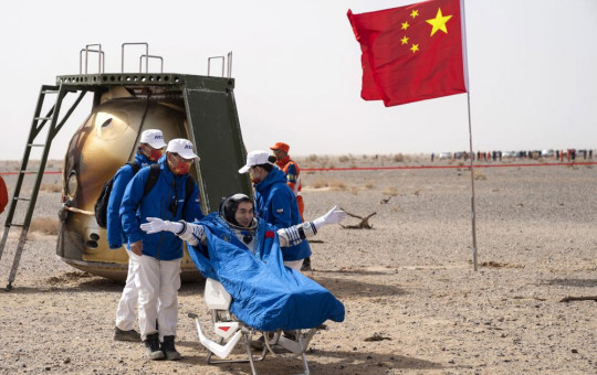 Chinese astronaut Ye Guangfu sits outside return capsule of the Shenzhou-13 manned space mission after landing at the Dongfeng landing site in northern China's Inner Mongolia Autonomous Region, Saturday, April 16, 2022.