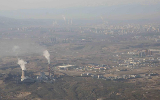FILE - Smoke and steam rise from towers at the coal-fired Urumqi Thermal Power Plant as seen from a plane in Urumqi in western China's Xinjiang Uyghur Autonomous Region on April 21, 2021.