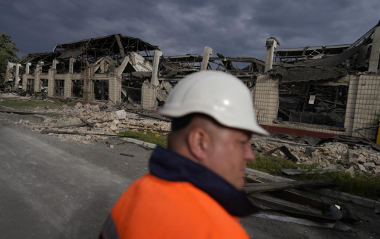 A worker looks at a railway service facility hit by a Russian missile strike in Kyiv, Ukraine, Sunday, June 5, 2022.