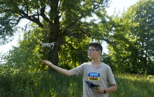 Andriy Pokrasa, 15, lands his drone on his hand during an interview with The Associated Press in Kyiv, Ukraine, Saturday, June 11, 2022.