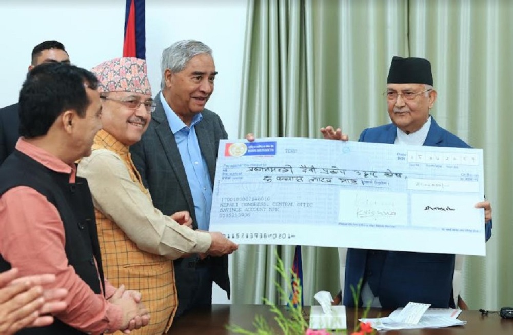 FILE - Nepali Congress President Sher Bahadur Deuba (second right) and other leaders hand over a check for Rs 5 million to Prime Minister KP Sharma Oli (right) in Kathmandu on October 6, 2024.