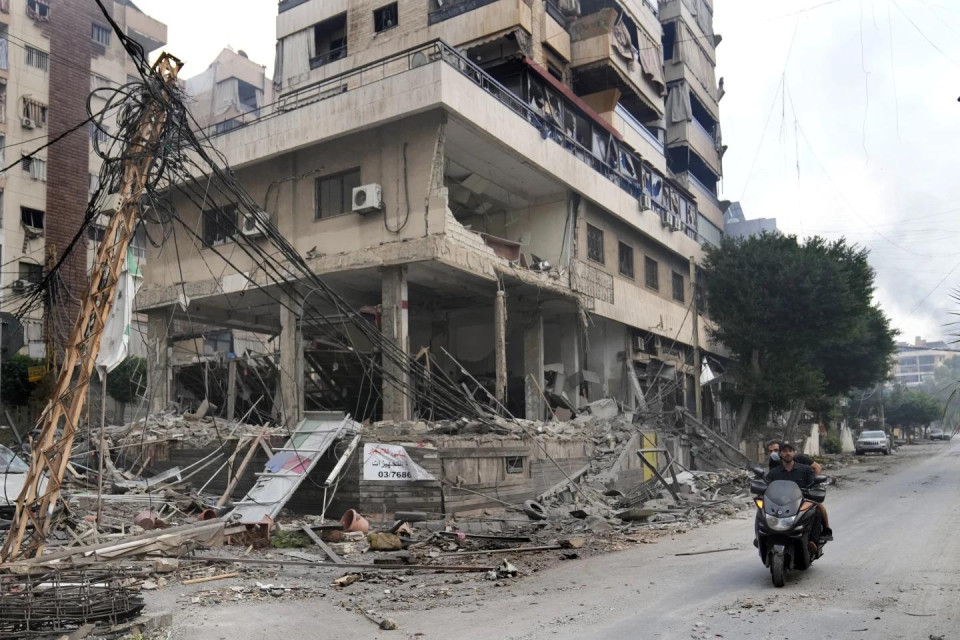 Lebanese men ride a scooter past a damaged building hit by an Israeli airstrike in Dahiyeh, Beirut, Lebanon, Monday, Oct. 7, 2024. (AP Photo)