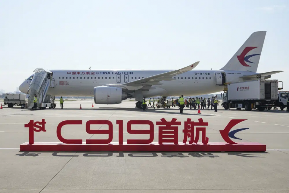 In this photo released by Xinhua News Agency, a sign which reads "1st C919 inaugural flight" is seen in front of the Chinese made passenger aircraft prepared for its first commercial flight from Shanghai on Sunday, May 28, 2023.