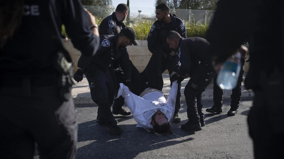 FILE - Israeli police officers remove an ultra-Orthodox Jewish man from the street during a protest against army recruitment in Jerusalem on June 2, 2024. (AP Photo)