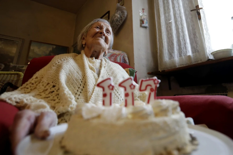 FILE- Emma Morano holds a cake with candles marking 117 years on the day of her birthday, Nov. 29, 2016, in Verbania, Italy. AP/RSS Photo