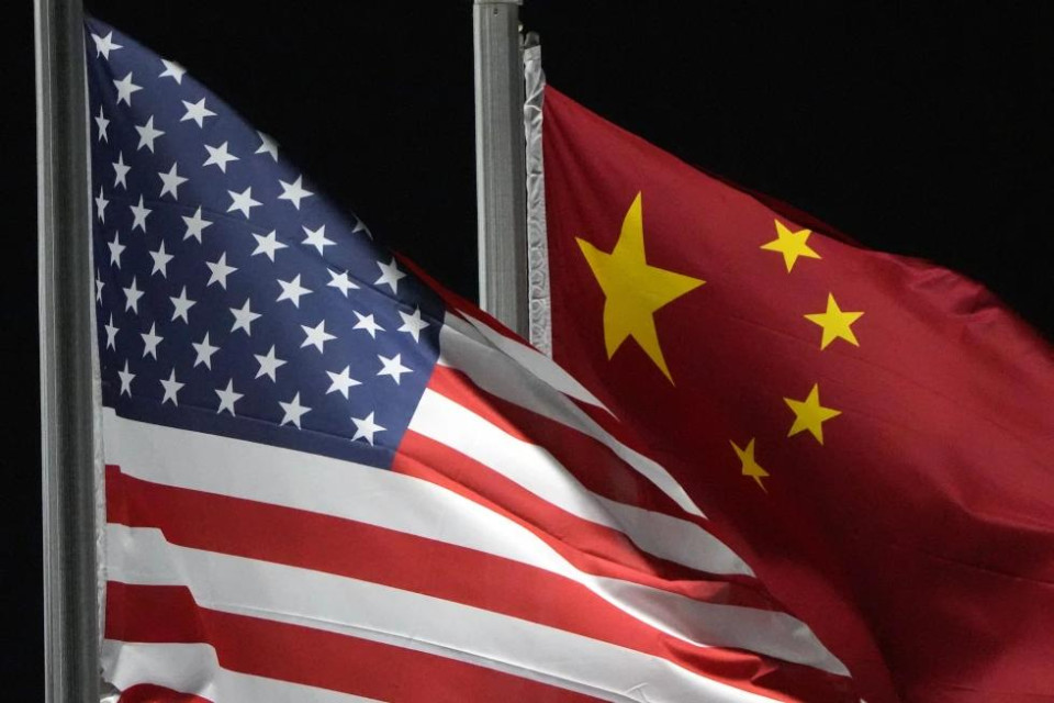 FILE - The American and Chinese flags wave at Genting Snow Park ahead of the 2022 Winter Olympics, Feb. 2, 2022, in Zhangjiakou, China. (AP Photo)