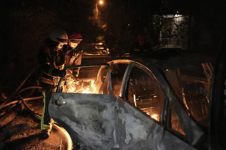 Emergency workers extinguish a fire in a parked car, caused by falling debris from the latest aerial Russian attack in the Pecherskyi district of Kyiv, Ukraine, Tuesday, May 30, 2023.  AP/RSS Photo