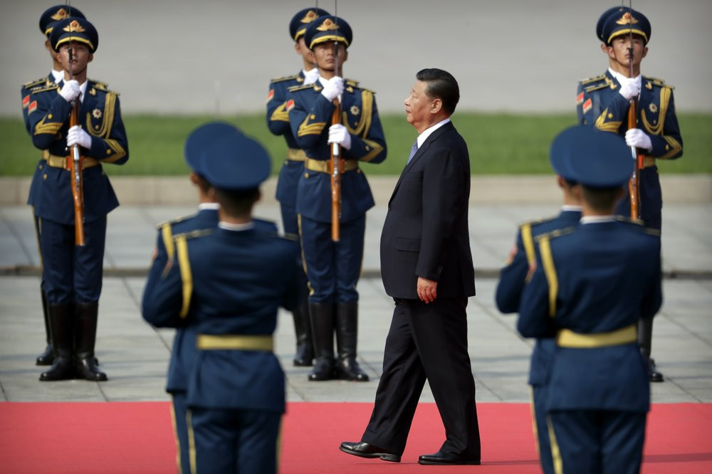 Chinese President Xi Jinping walks past an honor guard as he approaches the Monument to the People's Heroes during a ceremony to mark Martyr's Day at Tiananmen Square in Beijing, Monday, Sept