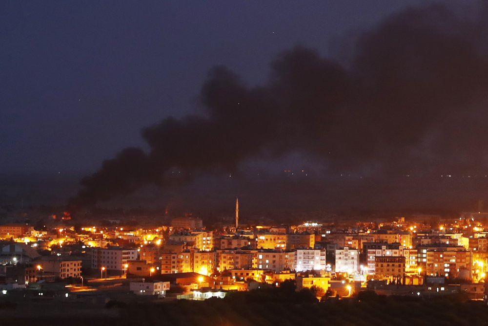 In this photo taken from the Turkish side of the border between Turkey and Syria, in Ceylanpinar, Sanliurfa province, southeastern Turkey, smoke billows from fires in Ras al-Ayn, Syria, cause