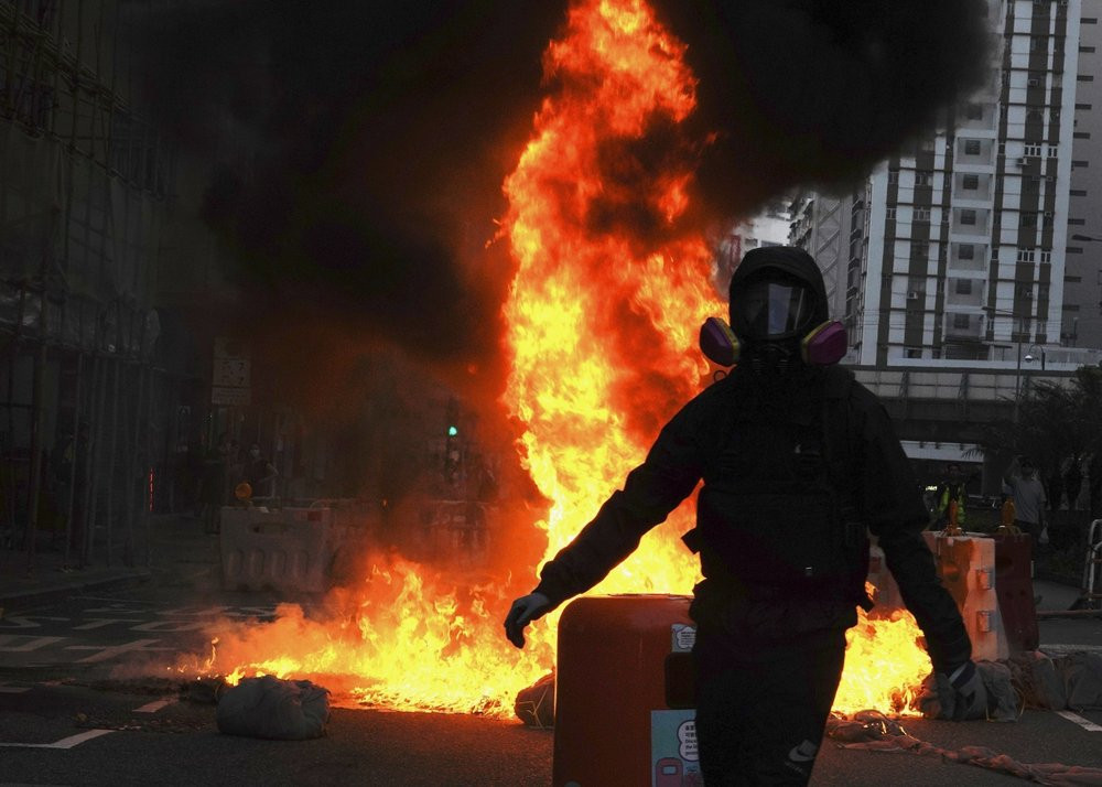 Protestors set fire on a street to prevent police from approaching in Hong Kong, Sunday, Oct. 20, 2019.