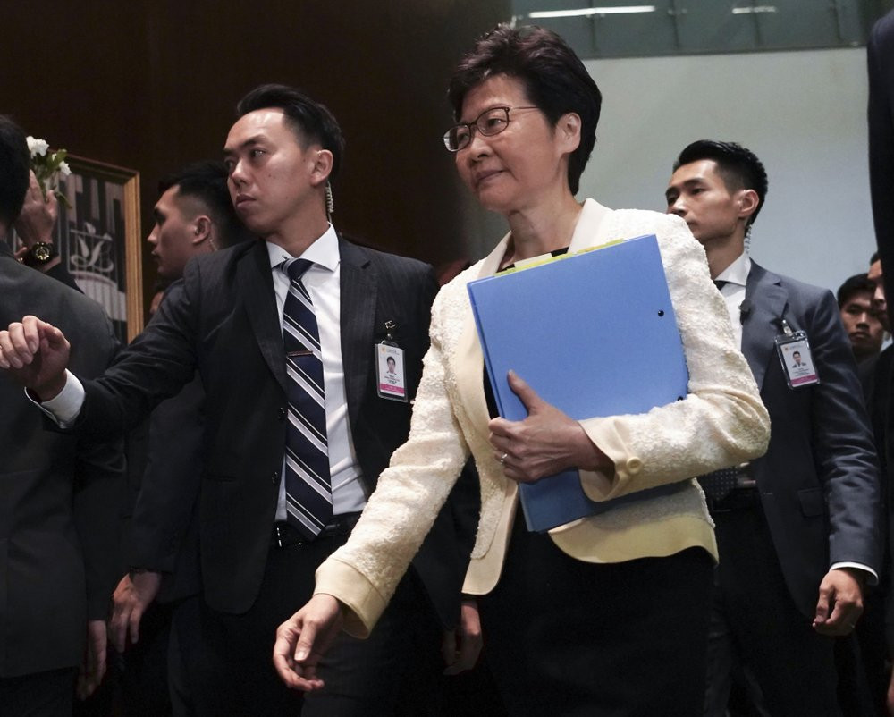 In this Oct. 17, 2019, file photo, Hong Kong Chief Executive Carrie Lam, center, arrives at chamber of the Legislative Council in Hong Kong.