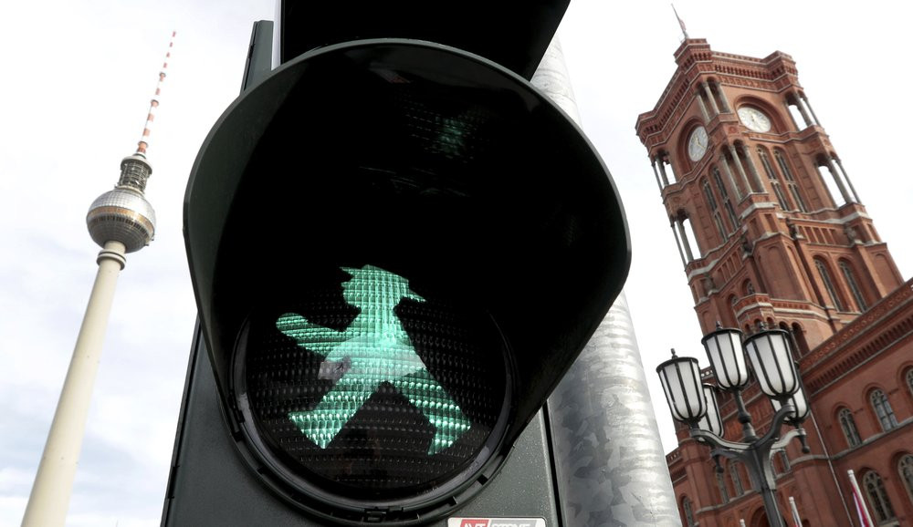 In this Tuesday, Oct. 22, 2019 photo a little traffic-light man is pictured in front of the Berlin TV Tower, left, and the 'Rotes Rathaus' (red townhall), right, in Berlin, Germany.