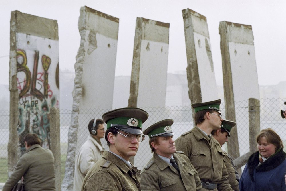 In this Nov. 13, 1989, file photo, East German border guards stand in front of segments of the Berlin Wall, which were removed to open the wall at Potsdamer Platz passage in Berlin.