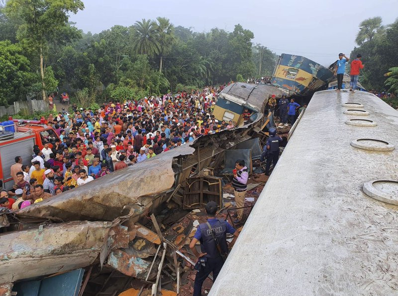 People gather near badly damages coaches after two speeding trains collided in in Brahmanbaria district, 82 kilometers (51 miles) east of the capital, Dhaka, Bangladesh, Tuesday, Nov.12, 2019